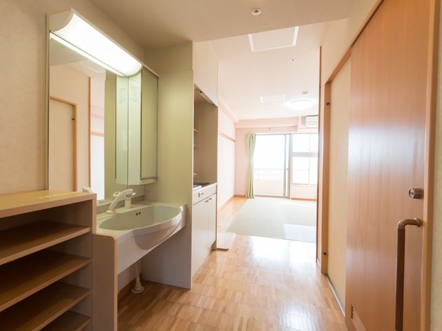 居室の明るい内装 居室 洗面台と多目的スペースを備えた快適な居住空間です。日々の生活を安心して過ごせる環境が整っています。