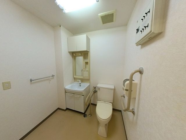 清潔なトイレ空間 トイレ 手すり付きで安全性を考慮した広々としたトイレです。利用者の快適さを重視しています。