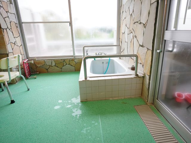 明るい浴室の一部 浴室 床は滑りにくい素材で、安全に配慮された設計の浴室です。大窓からの光が明るい雰囲気を演出しています。