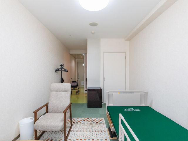 居室の一角 居室 広々とした居室には、くつろげる椅子があります。手前のベッドでは快適に過ごせます。