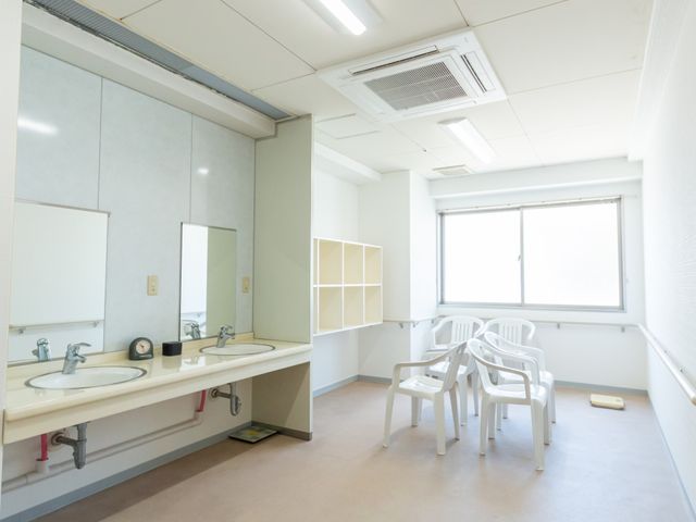 清潔な洗面台の部屋 洗面台 自然光が差し込む明るい洗面台のある部屋です。椅子が並び、ゆったり過ごせる空間になっています。