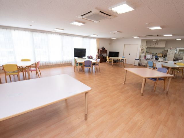広々とした共用スペース 食堂 ゆったりとした多目的室は様々な活動に適しており、開放的な雰囲気の中でケアを提供することができます。明るい窓側の席では静かに過ごすことも可能です。