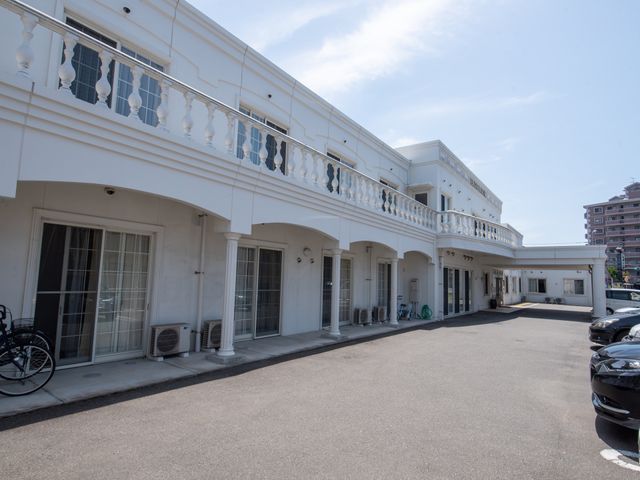 白亜の建物の外観 外観 ゆったりとしたアプローチが特徴的な白亜の建物です。周囲に緑が配置され、落ち着いた雰囲気の中でお仕事ができる環境です。