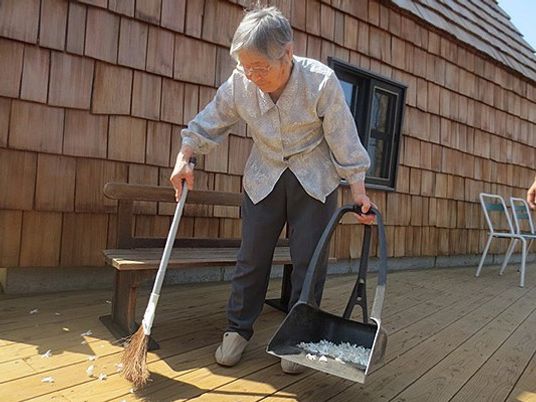 掃除する高齢の女性