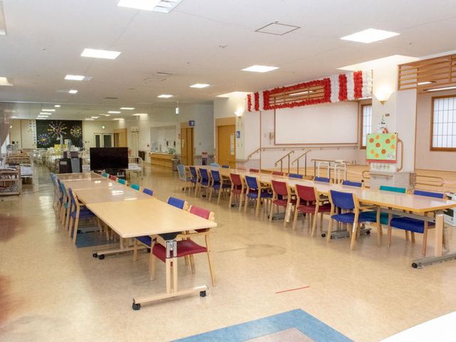開放的な広間 食堂 広々とした明るい空間で、多様なカラフルな椅子が並んでいます。食事や団らんの時間を快適に楽しめます。