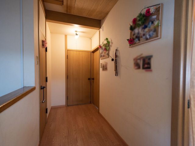 廊下に飾り付け 通路 暖かみのある木目調の廊下は、壁に飾られた花や写真たちがアクセントになっており、訪れる方に落ち着きと和みを提供しています。