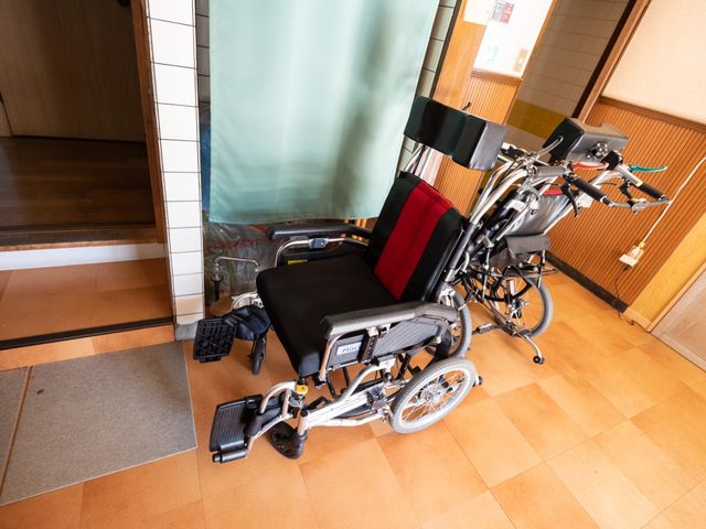 廊下に配置された車椅子 通路 ゆったりとした廊下には便利な車椅子が準備されており、快適な移動を支援しています。利用者の快適な生活を考えた心遣いが感じられる環境です。