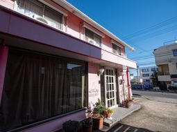 ピンクの建物エントランス