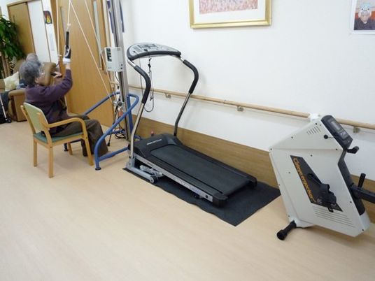運動器具と使用中の高齢者