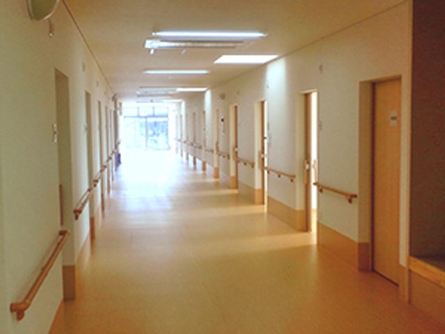 清潔感のある広々とした廊下 廊下 手すりが備えられた明るい廊下が、安全で心地よい移動空間を提供しています。清潔で落ち着いた彩りが、訪れる人にとって居心地の良さを感じさせます。