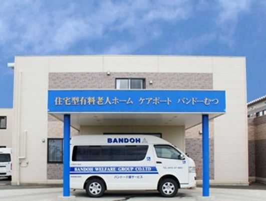 施設外観と送迎車の建物前  