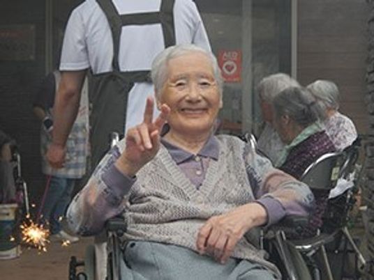 笑顔の高齢女性とスタッフ