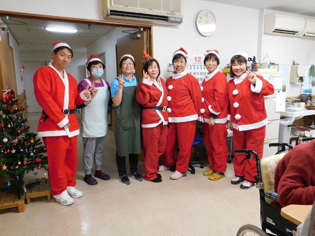 スタッフのホリデー装い イベント 職員がホリデーシーズンを彩る衣装でポーズを取っており、和やかな雰囲気が伝わります。チームワークを大事にしている職場です。