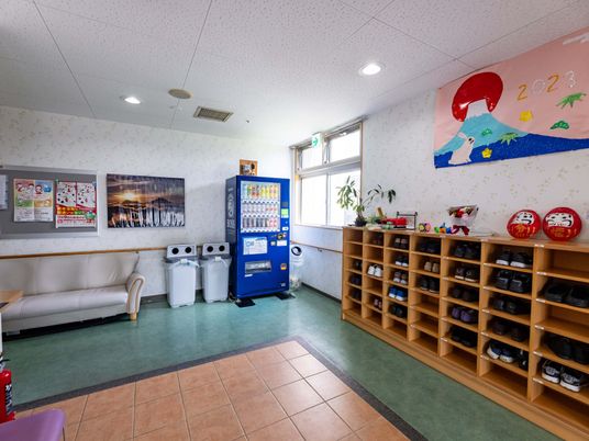 だるまが飾られている下足箱と自販機