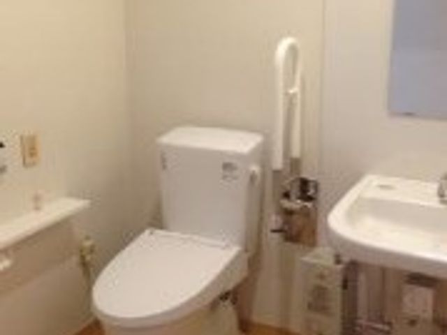 清潔なトイレ施設 トイレ 手すり付きの洗練されたトイレスペース。安全に配慮された構造で、働くスタッフにとっても利用者にとっても使いやすくなっています。