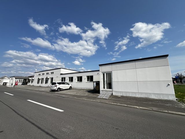 白い建物の外観 外観 広い敷地に配置されたシンプルなデザインの白い建物です。空が広がり、開放的な印象を与えます。