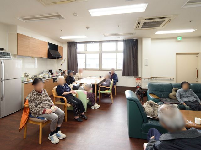 共同生活スペースの一覧 食堂 居心地の良いリビングで、利用者の皆さまが何気ない会話を楽しんでいます。明るく家庭的な雰囲気が就業意欲を高めるでしょう。