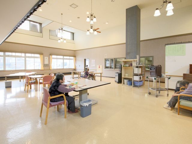 ゆったりとした多目的室 多目的室 広々とした多目的室では、いくつかのテーブル周りに座る方々が、寛ぎの時間を過ごしています。お一人お一人の居心地の良い空間がここにあります。