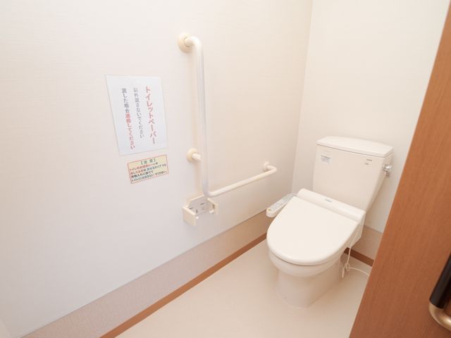 バリアフリー対応のトイレ トイレ 安全に配慮された設計のトイレです。手すりがついているため、立ち上がりや移動をサポートし、利用者の自立を促します。