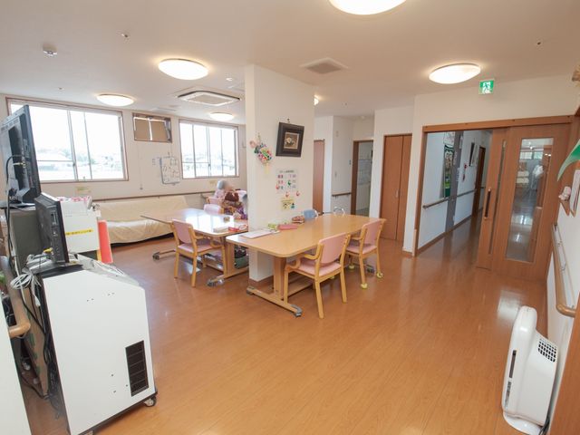 共有スペースと利用者 食堂 利用者が心地よい光の中で日々の活動に取り組んでいる、広々とした多目的室です。明るくて木の温もりを感じることができる空間が広がっています。
