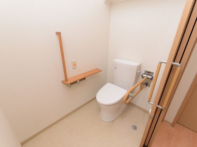 手すり付きの清潔なトイレ トイレ 安全を配慮したデザインのトイレです。手すりがついており、さまざまなニーズに対応できるよう工夫されています。