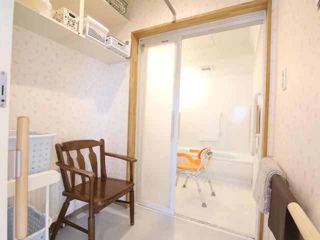 洗面所と浴室入口 浴室 広々とした入口でバリアフリーに配慮された浴室です。安全な入浴を支える手すりやシャワーチェアも整っております。