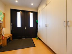 明るい廊下と木製ベンチ