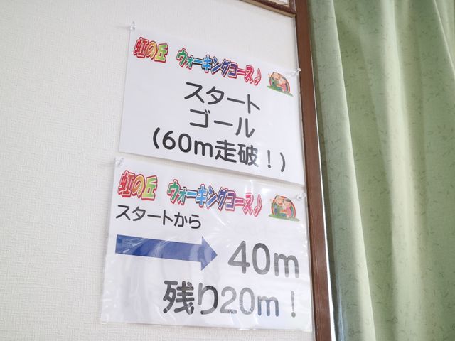 案内掲示物のクローズアップ 掲示板 壁に掲示された案内は、訪れる方々への距離表示や道案内を示し、皆様の歩行をサポートしています。