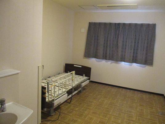 ベッドと洗面台のある居室  
