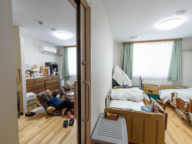 居室の日常風景 居室 ゆったりとした居室で、利用者がリラックスしながら過ごしています。木目調の家具が温もりを感じさせる空間です。
