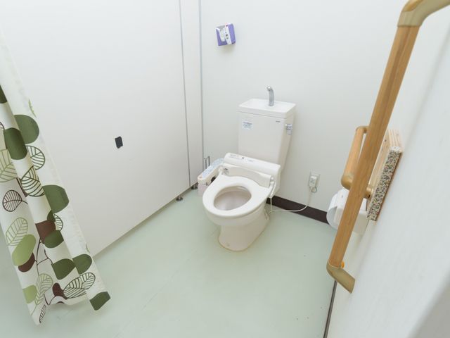 バリアフリートイレ設備 トイレ 握りやすい手すりが設置された清潔なトイレスペースです。利用者の安全と快適さを考慮した設計になっています。
