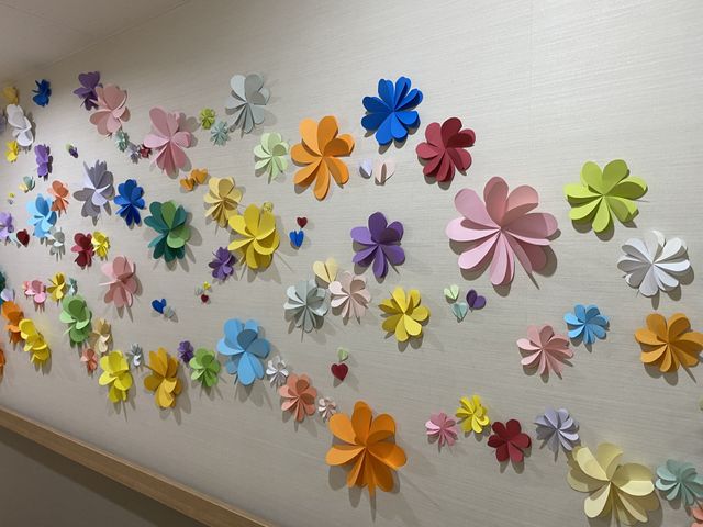 壁に飾られた花の装飾 廊下 廊下の壁を彩るカラフルな花の装飾が、明るく心温まる雰囲気を創出しています。