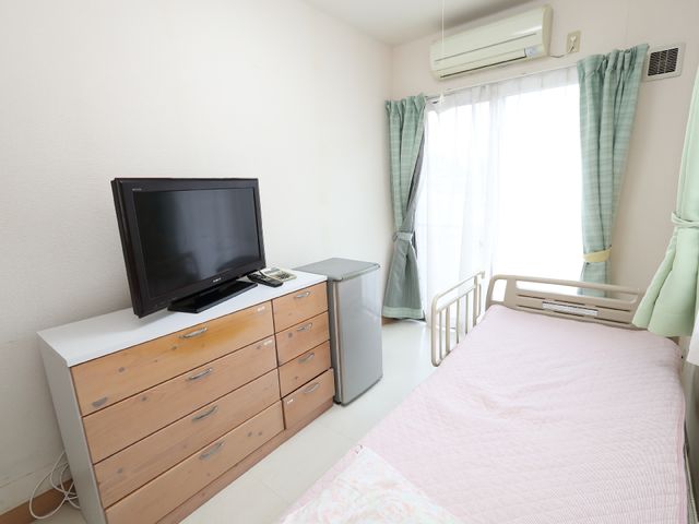 広々とした居室 居室 整理された居室には、必要な家具とテレビが揃い、居心地の良い個人空間を提供しています。窓からは自然光が差し込み、明るく開放的な雰囲気です。