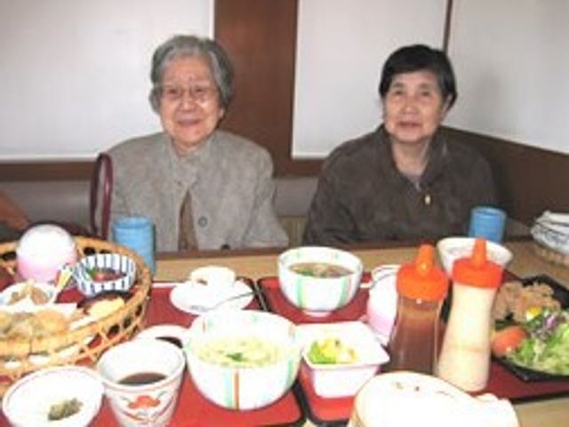 食事を囲む笑顔のご高齢者 食事会 共に食事を楽しむ温かなダイニング空間です。笑顔で会話を交わしながら、栄養満点のお食事をお召し上がりいただけます。