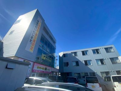 車が並ぶ居住施設の外観