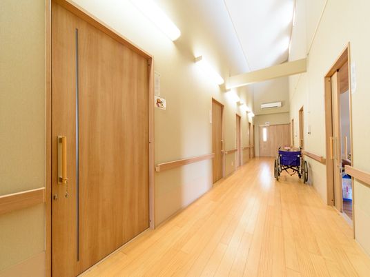 廊下は開放感がある高い天井になっている。壁には手すりが設置されている。車椅子が２台通れる広さがある。
