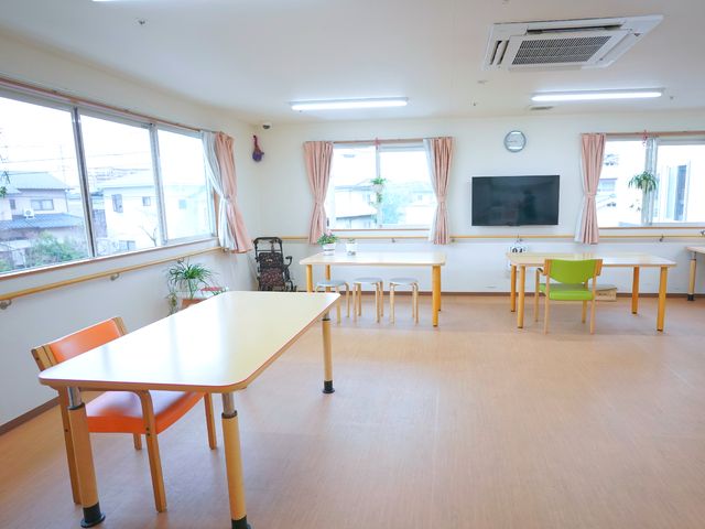明るい居室空間 共用スペース 広々とした食堂は明るい自然光が差し込み、快適な食事やコミュニケーションの場を提供しています。テレビも完備され、リラックスした時間を過ごせるよう設計されています。