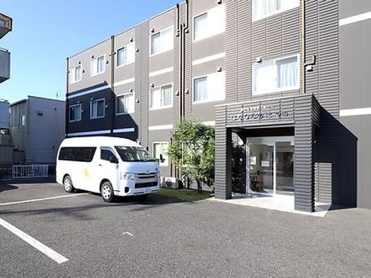 建物正面と送迎車の外観  
