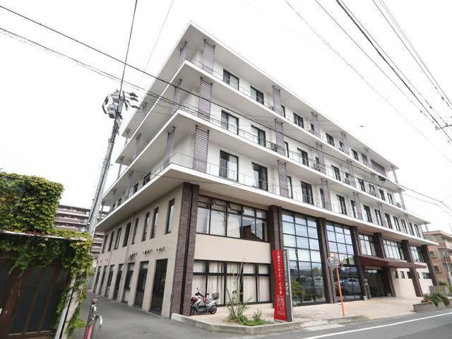 白い建物の外観 外観 現代的なデザインの建物エントランスが開放的で、明るい雰囲気を醸し出しています。安心して過ごせる勤務環境が提供されています。
