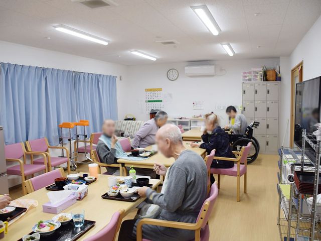 食事中の集いの場 食堂 広々とした空間で、利用者の皆さんが和やかに食事を楽しんでいます。車椅子も利用しやすい設計です。