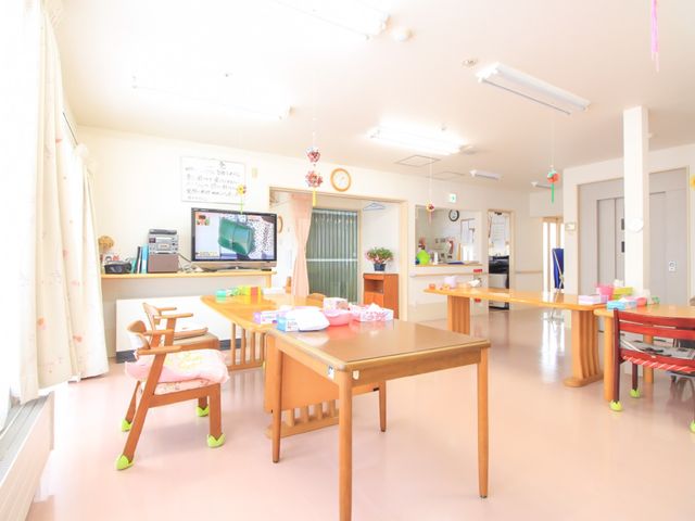 明るい共有リビング 食堂 広々とした明るい食堂で、利用者様は食事や憩いの時間を過ごされています。手すり付きの椅子や床の反射が少ない素材など、安心してお過ごしいただける工夫がされています。