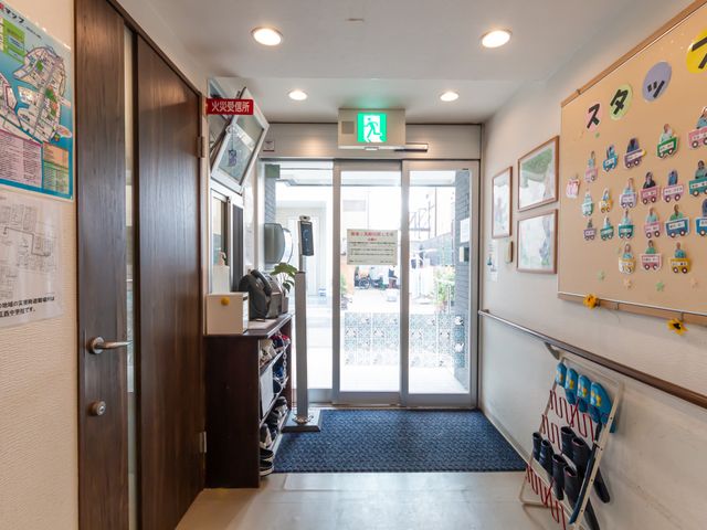 広い廊下の出口 エントランス 明るい雰囲気の廊下には、緊急時の避難経路がしっかりと示されています。スタッフの案内も充実して安心です。