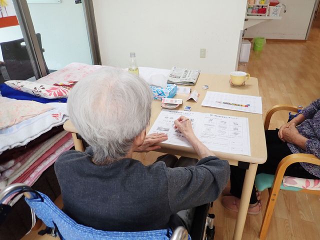 高齢者が紙に筆記中