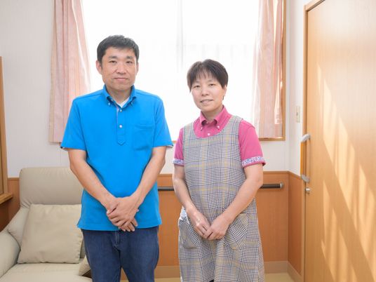 笑顔のスタッフ二人立つ居室