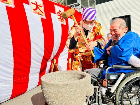 笑顔で餅つきする様子