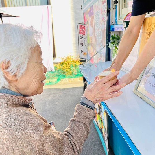 お年寄りが商品受け取る