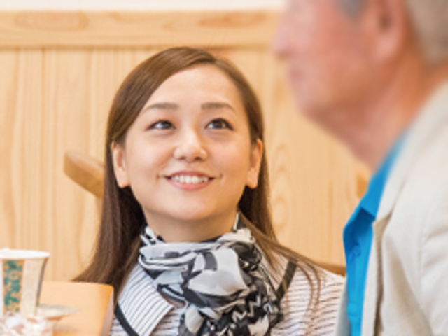スタッフと利用者の会話中 ラウンジ 広々としたラウンジで、笑顔で利用者とスタッフが交流しています。リラックスした雰囲気です。