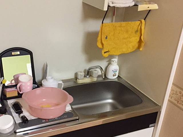 キッチンの流し台 キッチン   流し台と作業台がまとまっており、少人数での準備や後片付けがしやすそうです。タオルや洗剤が置かれ、日常の家事動線が見えます。