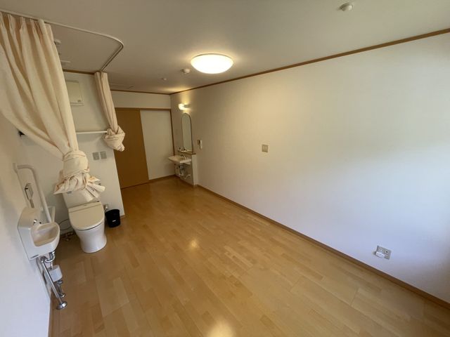 ゆったりとした居室 居室 床がフラットで明るい空間の居室です。日常生活に必要な設備が整い、くつろぎやすい環境があることが伺えます。
