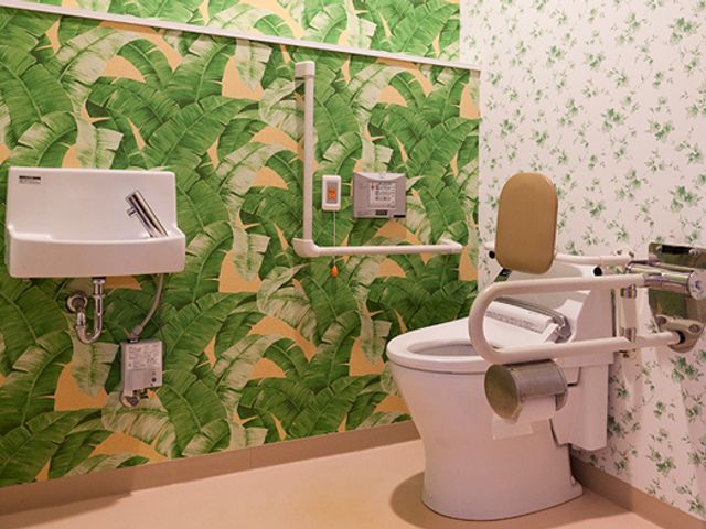 安心のトイレ空間 トイレ 自然を感じる壁紙が特徴の安全に配慮した空間です。利用者が安心して使用できます。